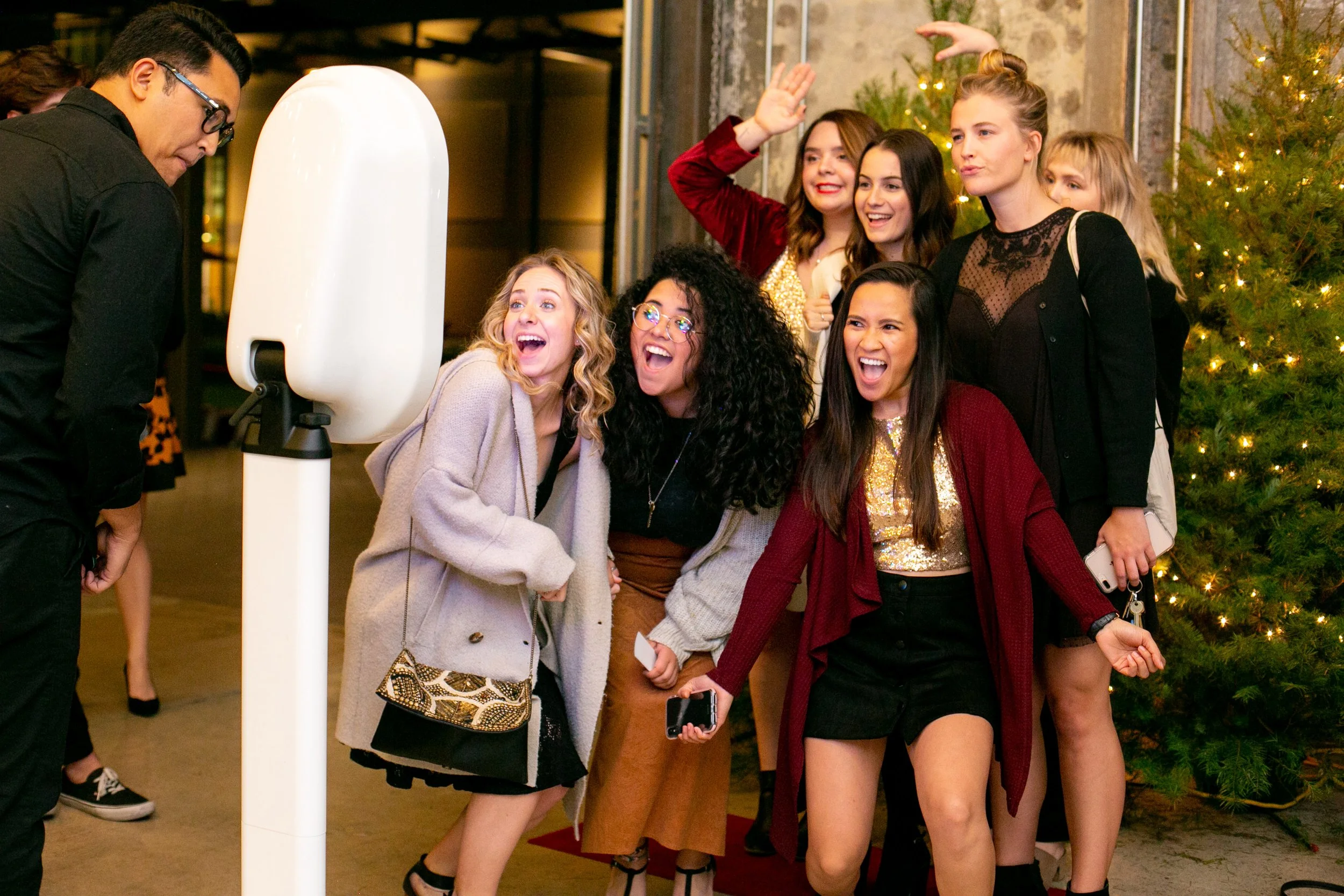 Group of friends posing and laughing in front of the photo booth