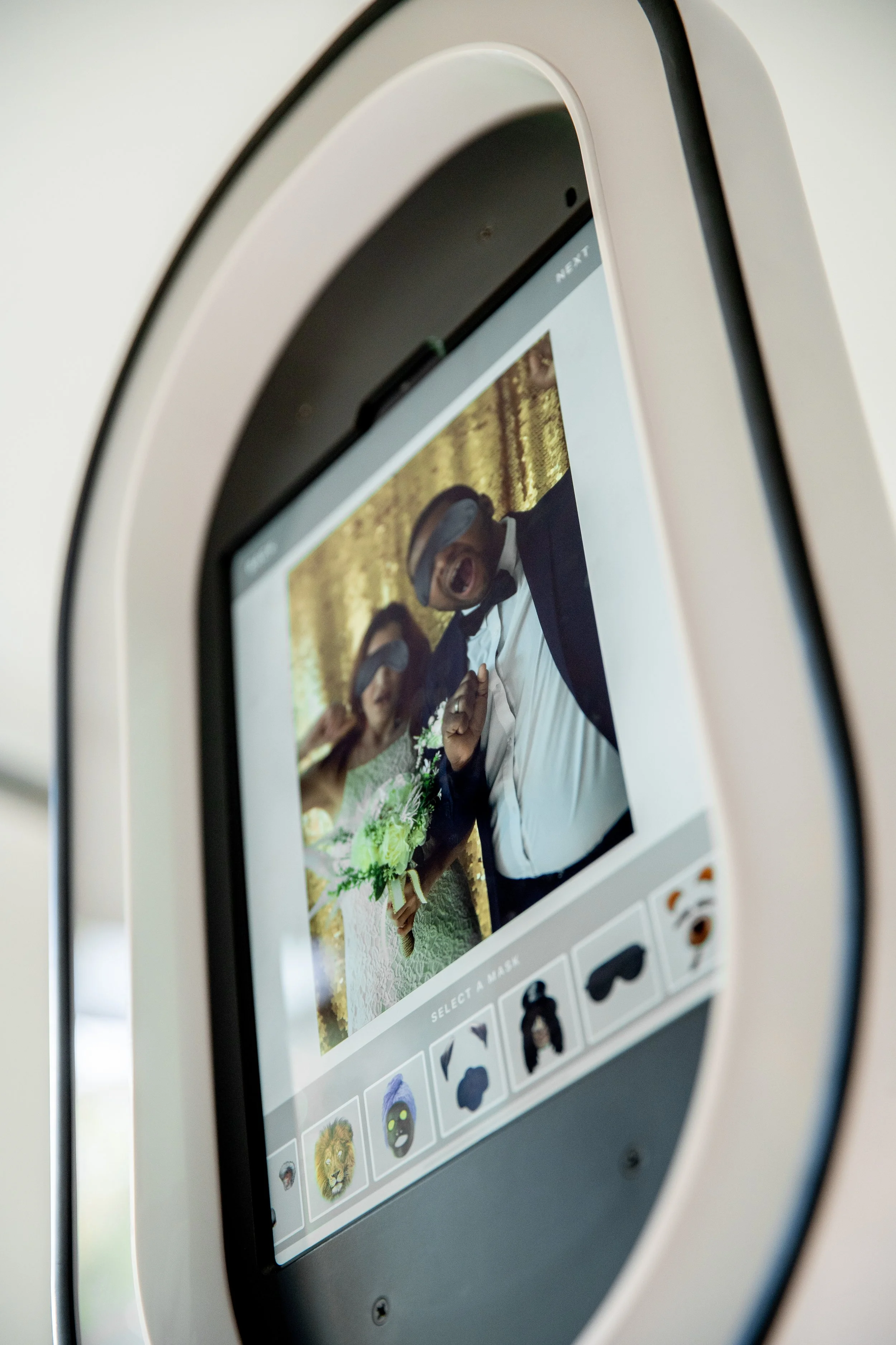 Photo booth screen showing a couple’s photo with digital prop options